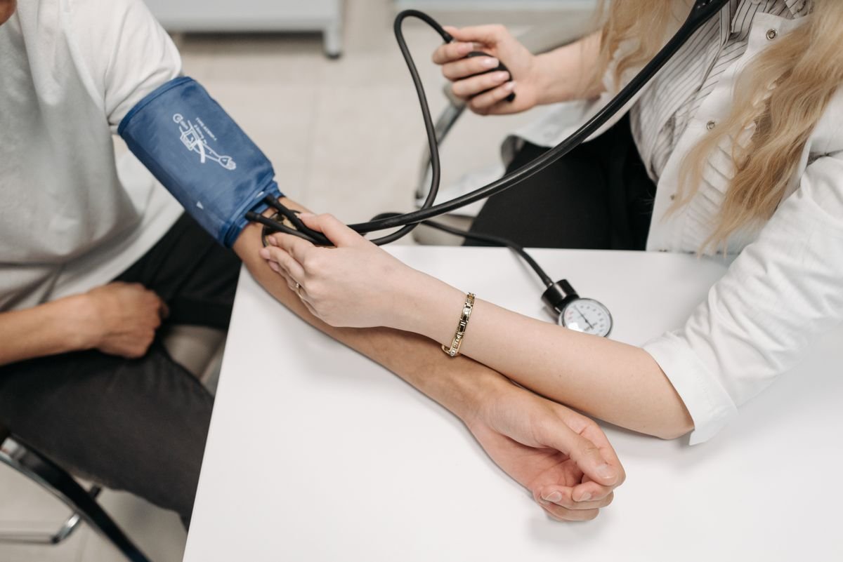 Healthcare professional checking a patient’s blood pressure during a clinical exam